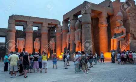 Les touristes regardent le soleil se coucher sur le temple de Karnak à Louxor